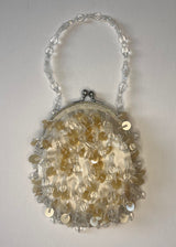 Decorative handbag with floral patterns and a chain handle on a light gray background