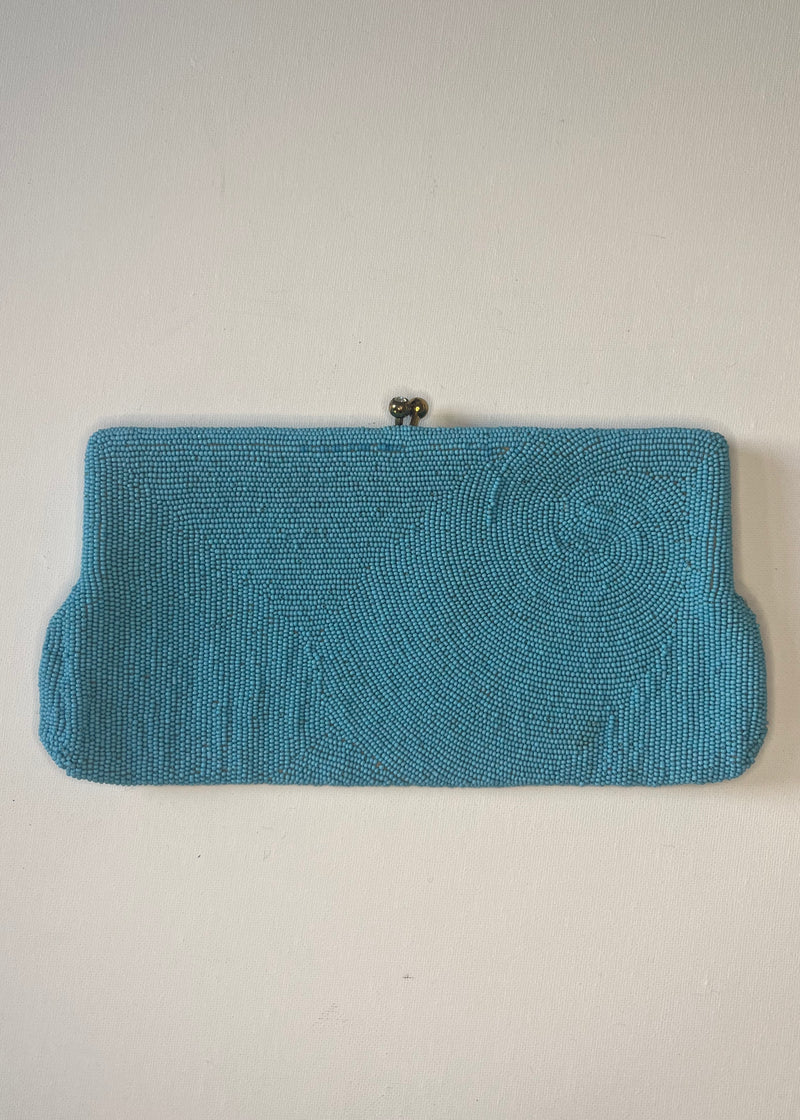 Blue beaded clutch bag on a light gray background