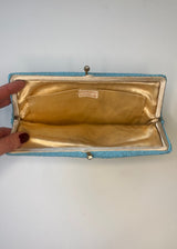 Open clutch bag with gold interior on a white background
