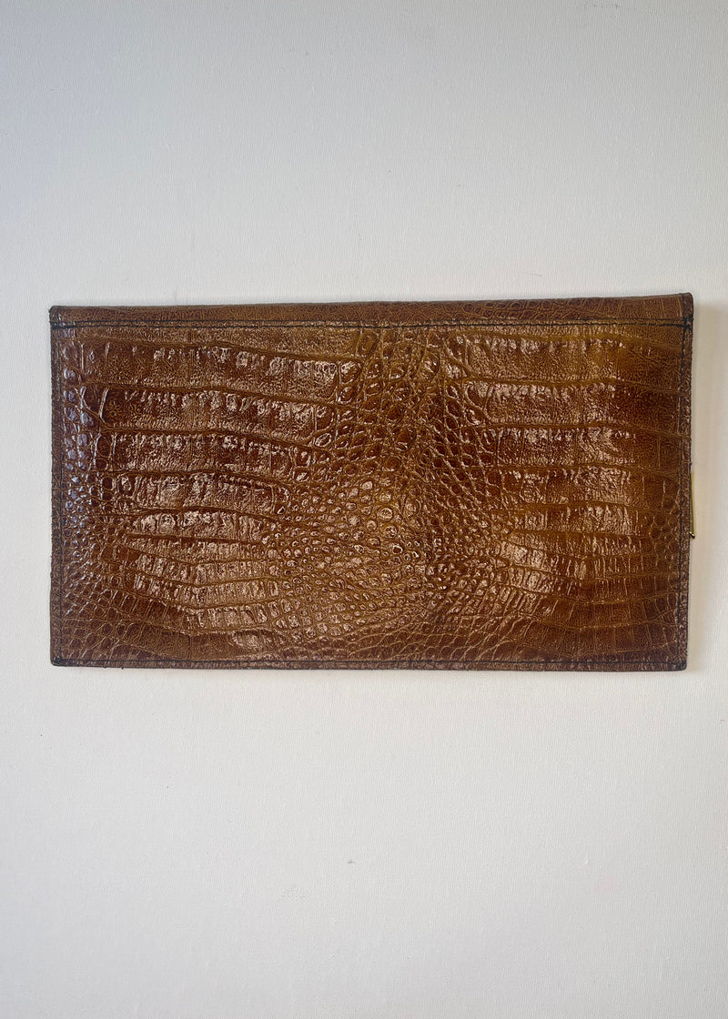 Brown crocodile skin wallet on a white background