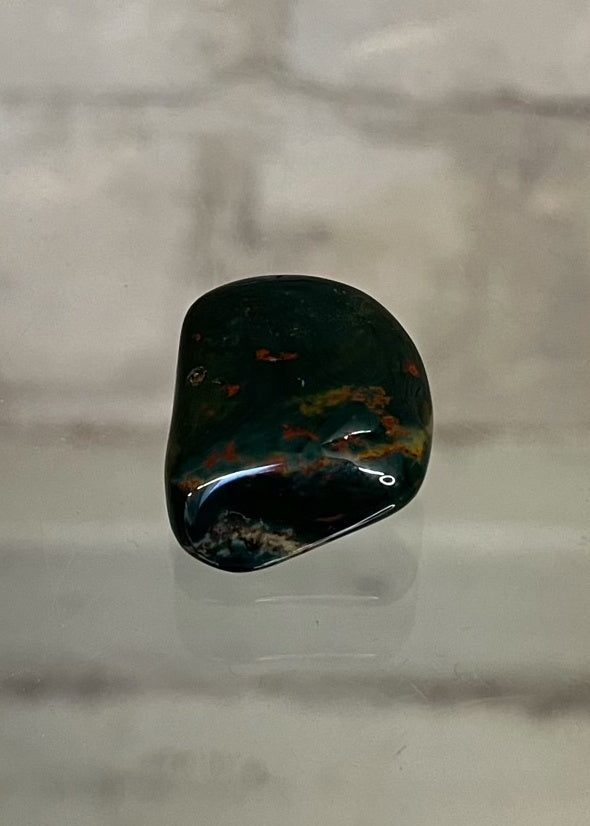 Bloodstone Tumble Stone Crystal  This beautiful stone’s energy carries the purity of blood, encouraging vitality, strength, independence, passion and courage.